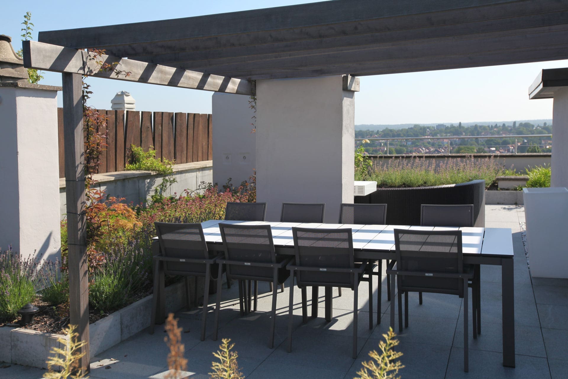 Langer Esstisch unter der Pergola auf der Dachterrasse