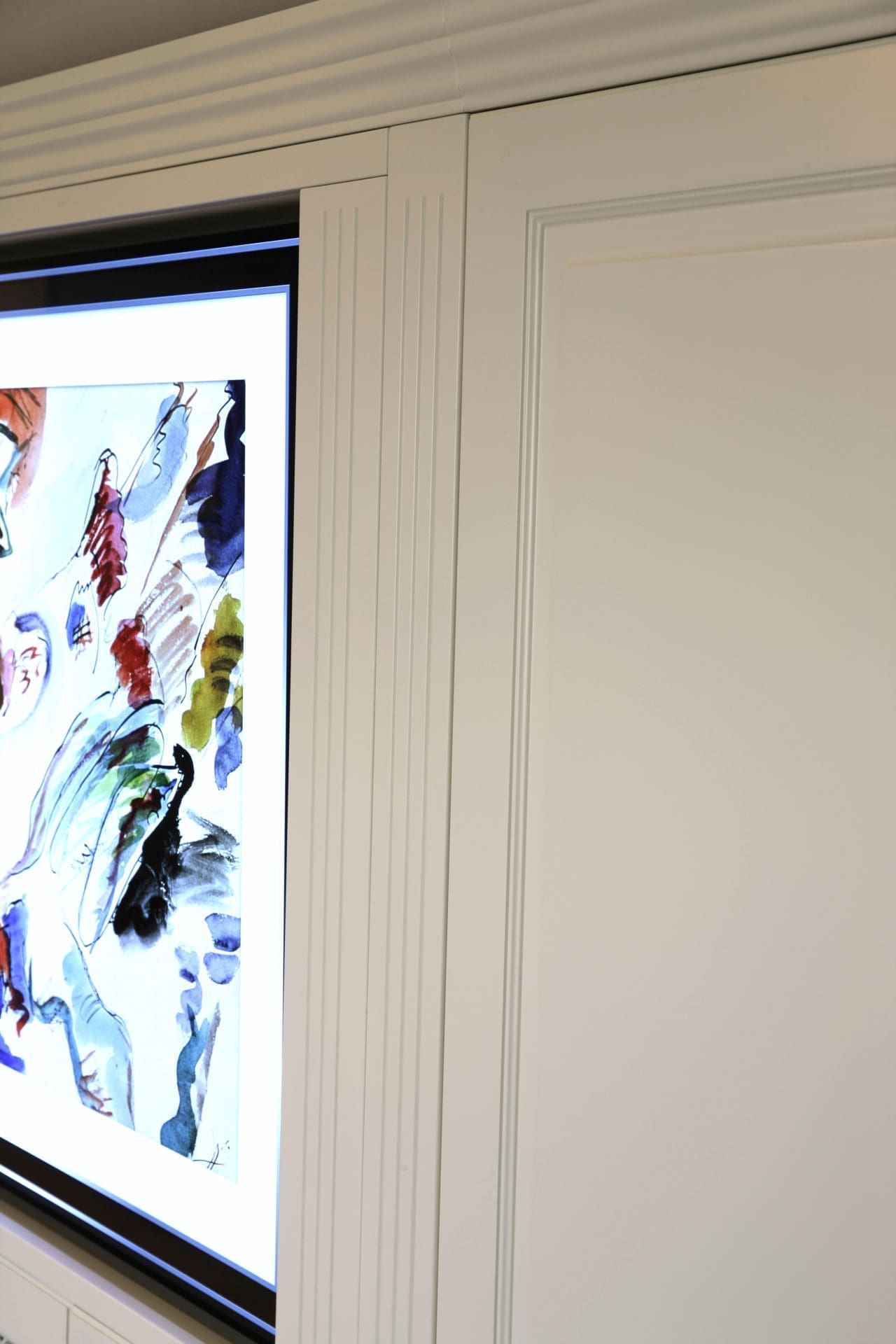 Witte kast met een geribd paneeldetail naast een verlicht kunstpaneel in kleur