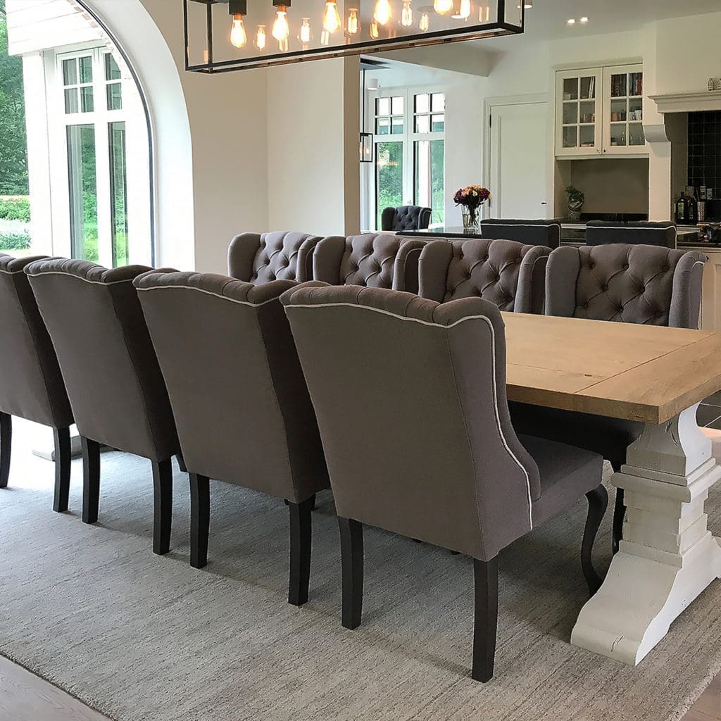 Eetplaats met een eiken tafel en gecapitonneerde stoelen in taupe