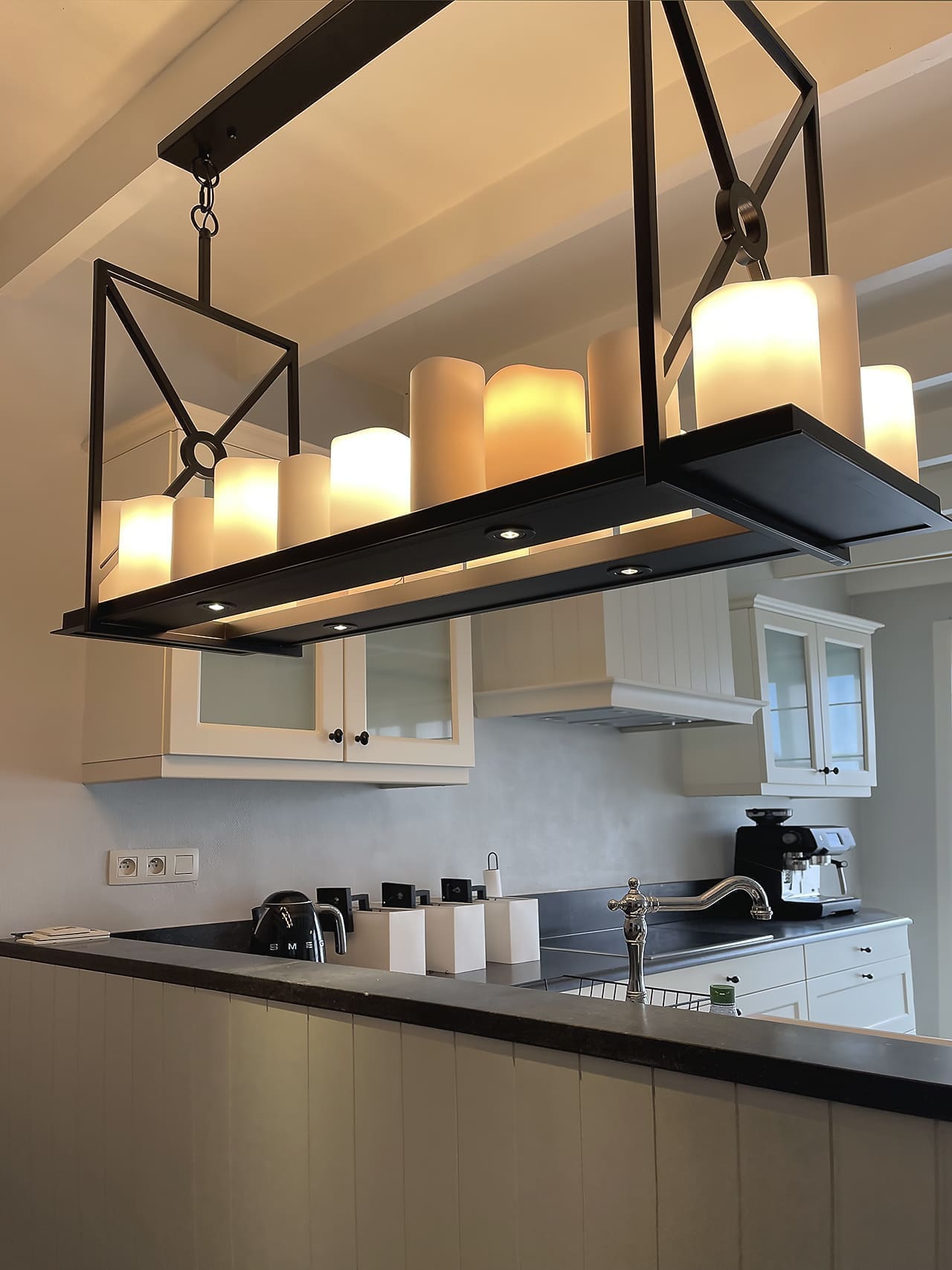 Hanglamp met kaarsen boven het werkblad in de keuken, woning bij Brussel