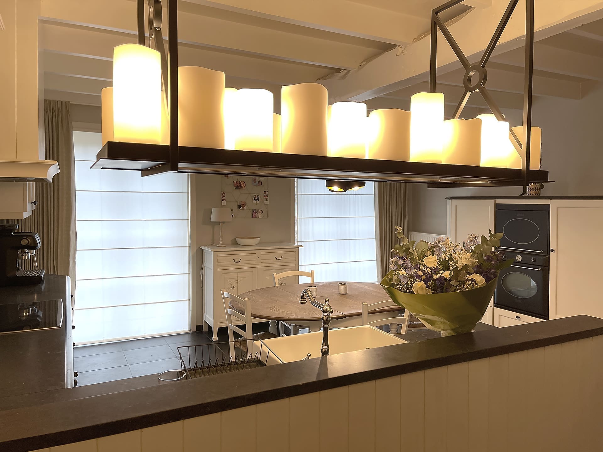 Hanglamp in zwart metaal met kaarsen boven het keukeneiland, woning bij Brussel