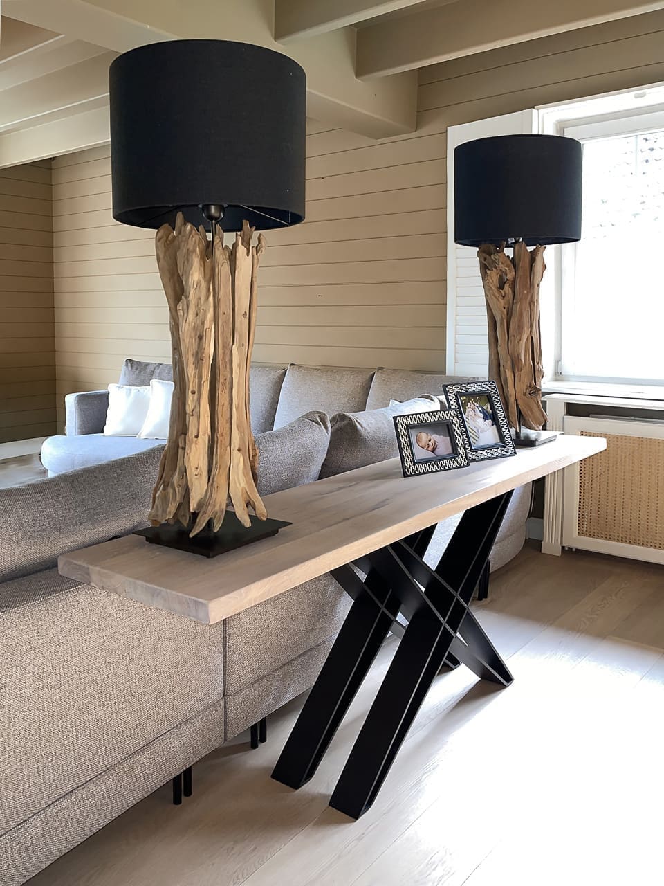 Konsole mit Lampen an einer Holzwand
