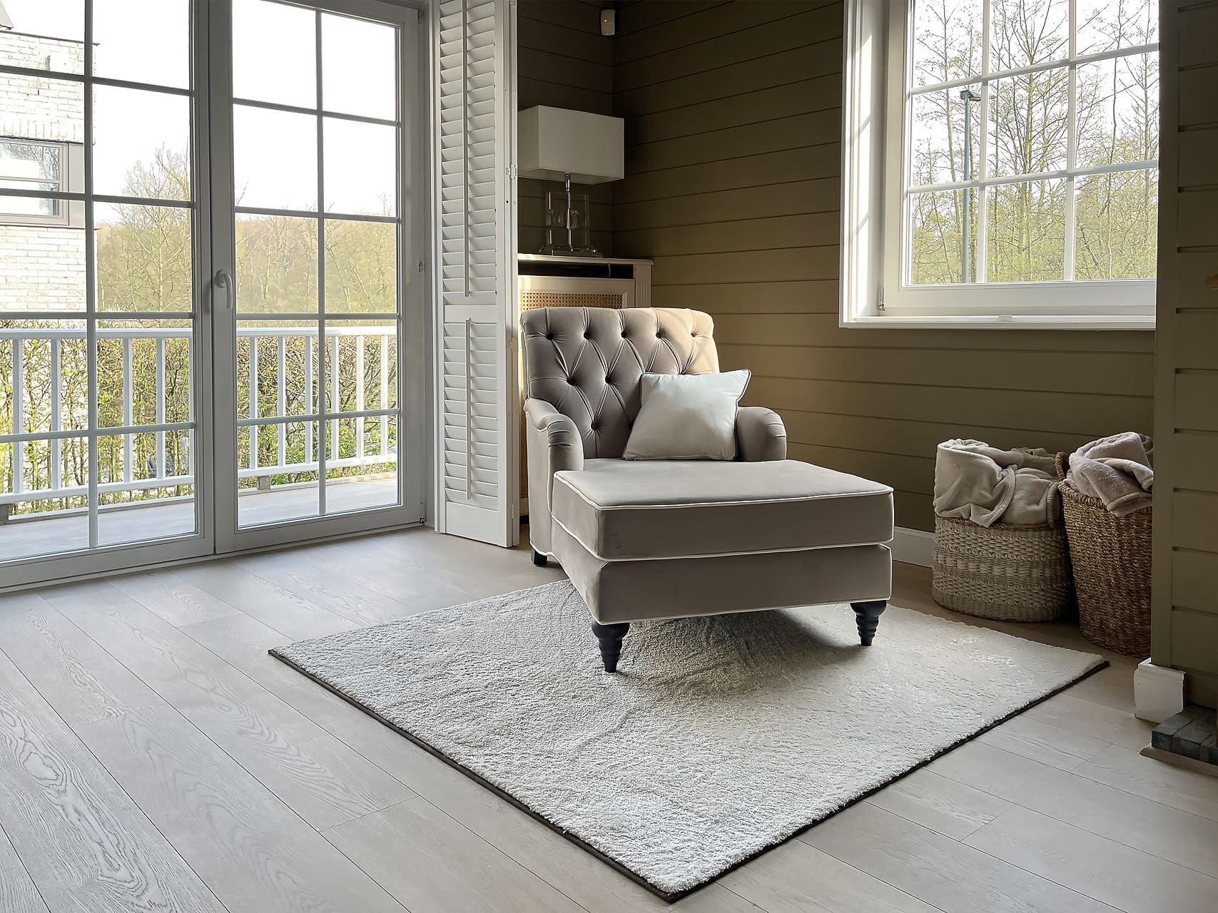 Chaise longue bij het raam met een rieten mand voor de plaids in Overijse