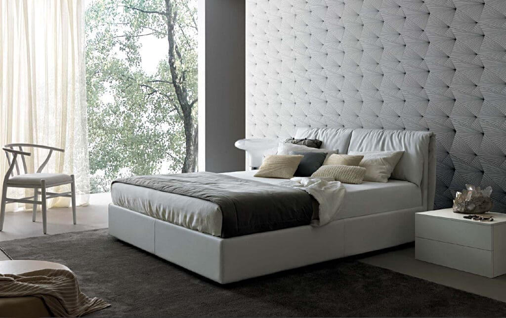 Slaapkamer met een gecapitonneerde wand achter het bed
