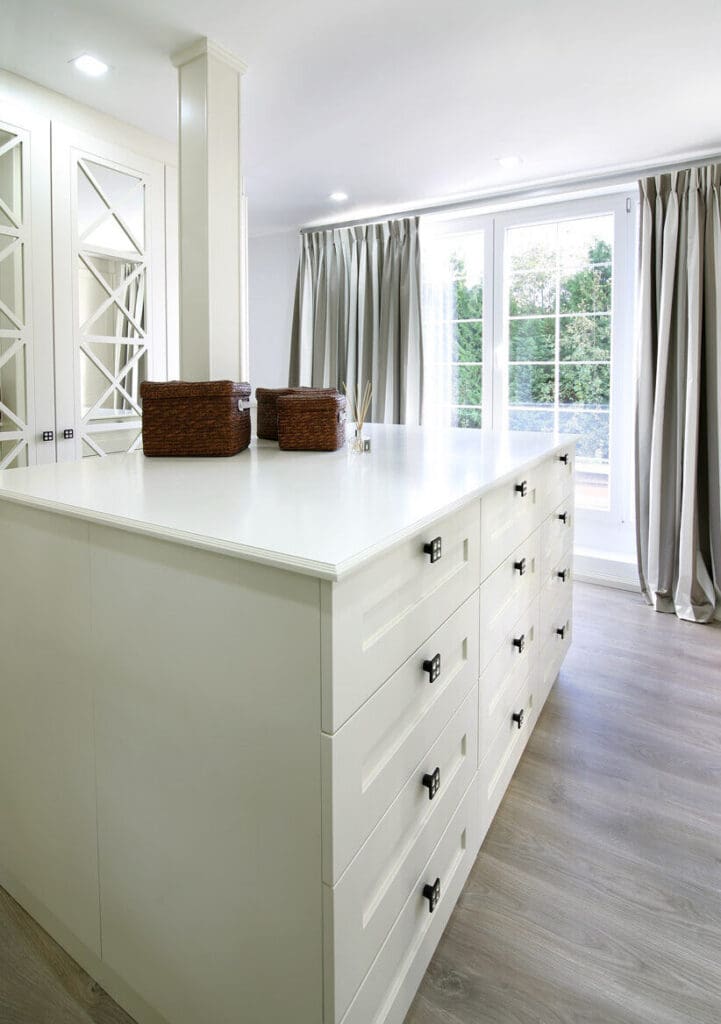Dressing op maat met een eiland vol laden en spiegelkasten