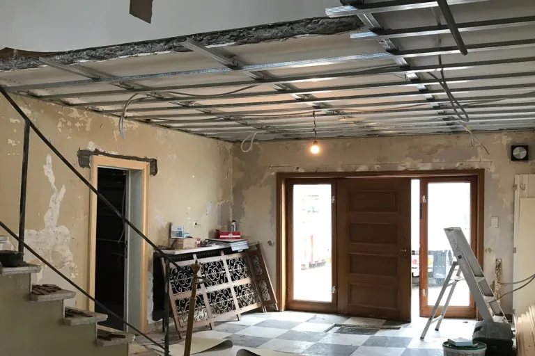 Een leefruimte na renovatie, met nieuw schrijnwerk tegen een bestaande raamopening.