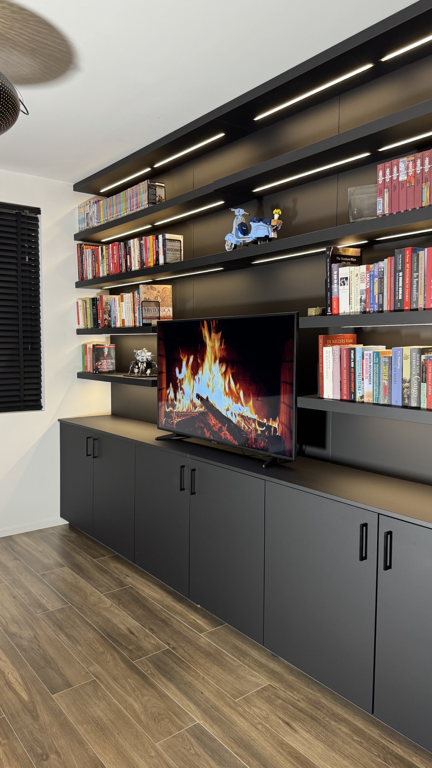 Boekenwand op maat over de volle wandbreedte, met tv-kast eronder