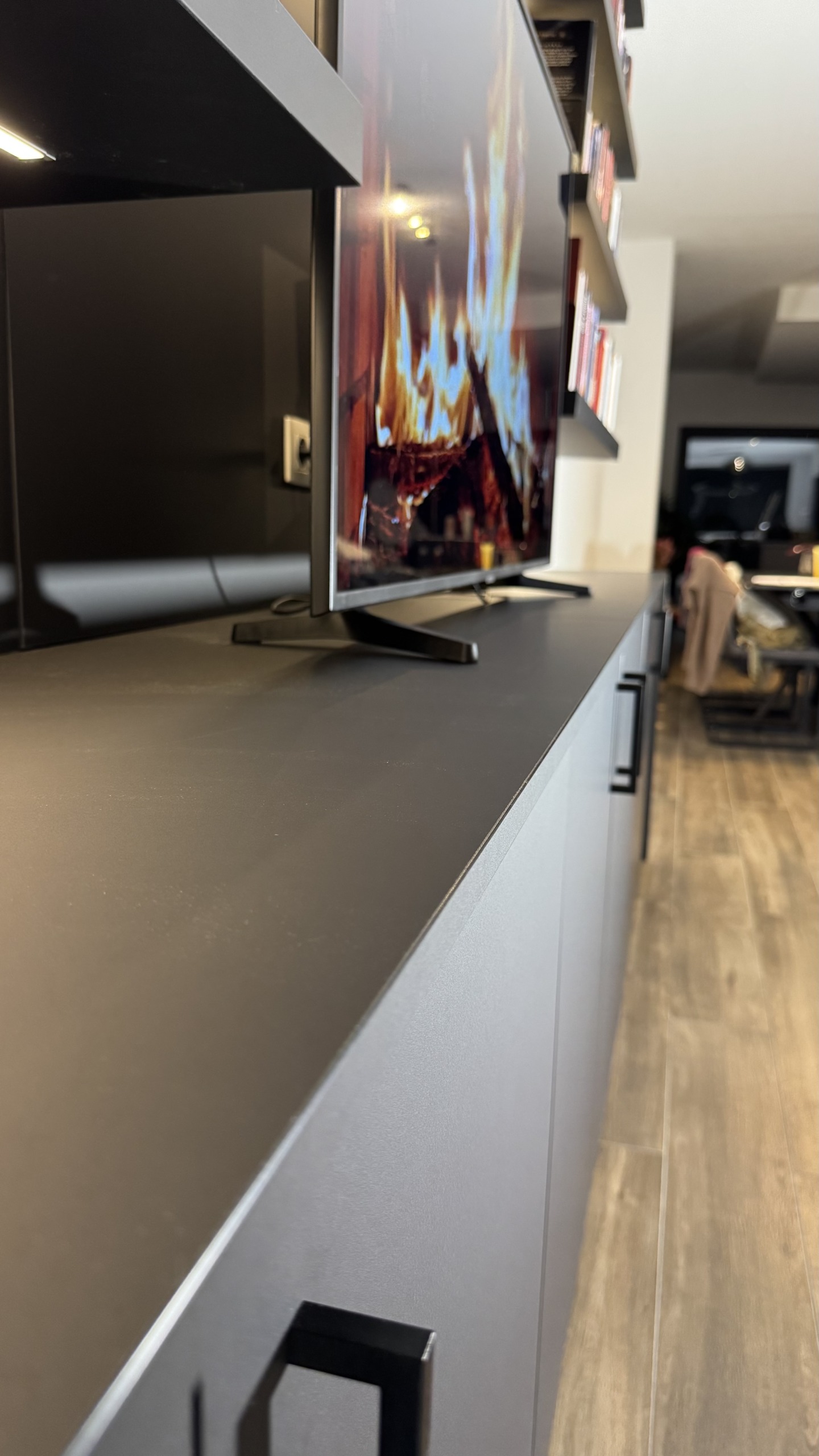 Het doorlopende bovenblad van de tv-kast in mat zwart
