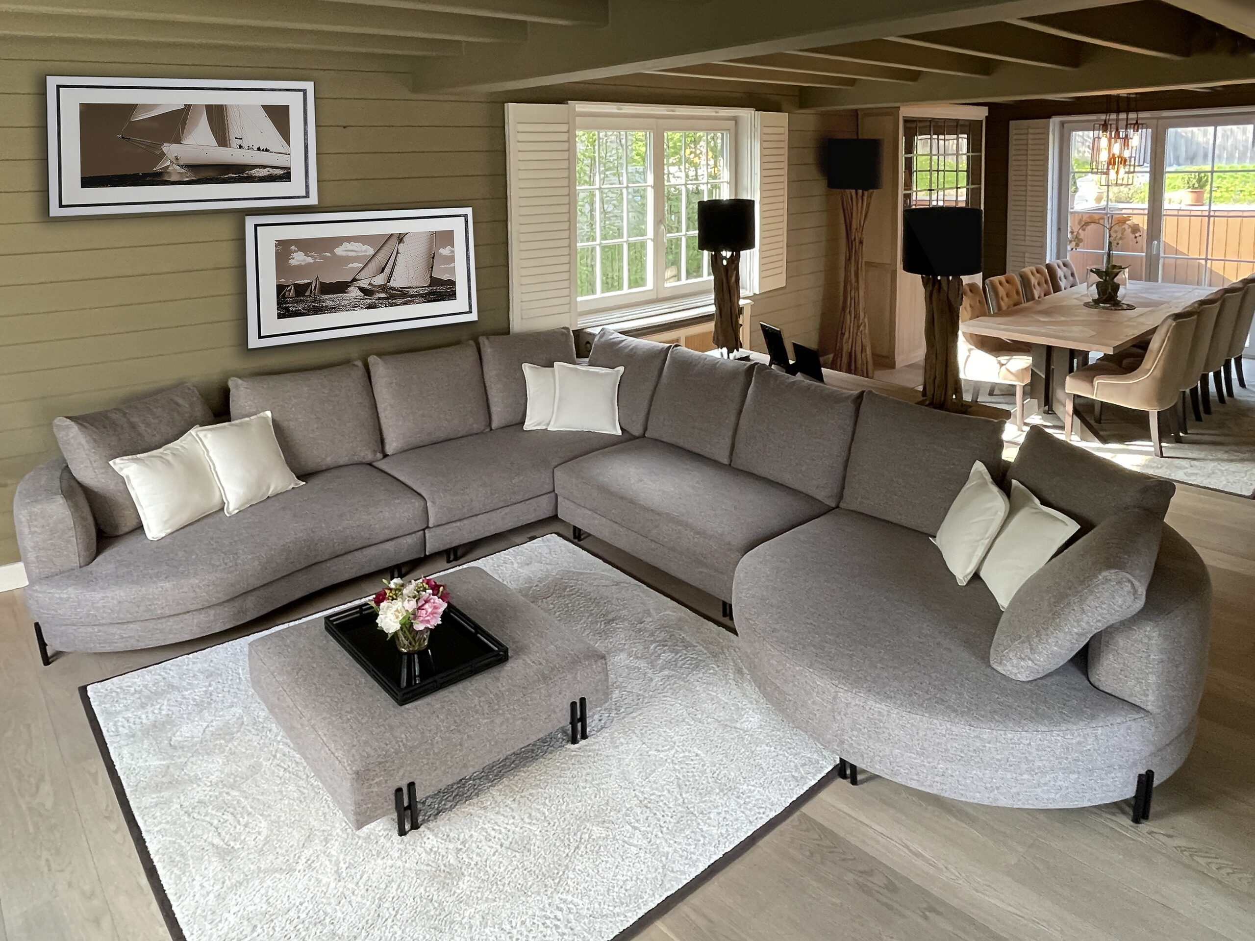 Landelijke salon in Overijse met grote hoeksofa in grijze stof en witte shutters