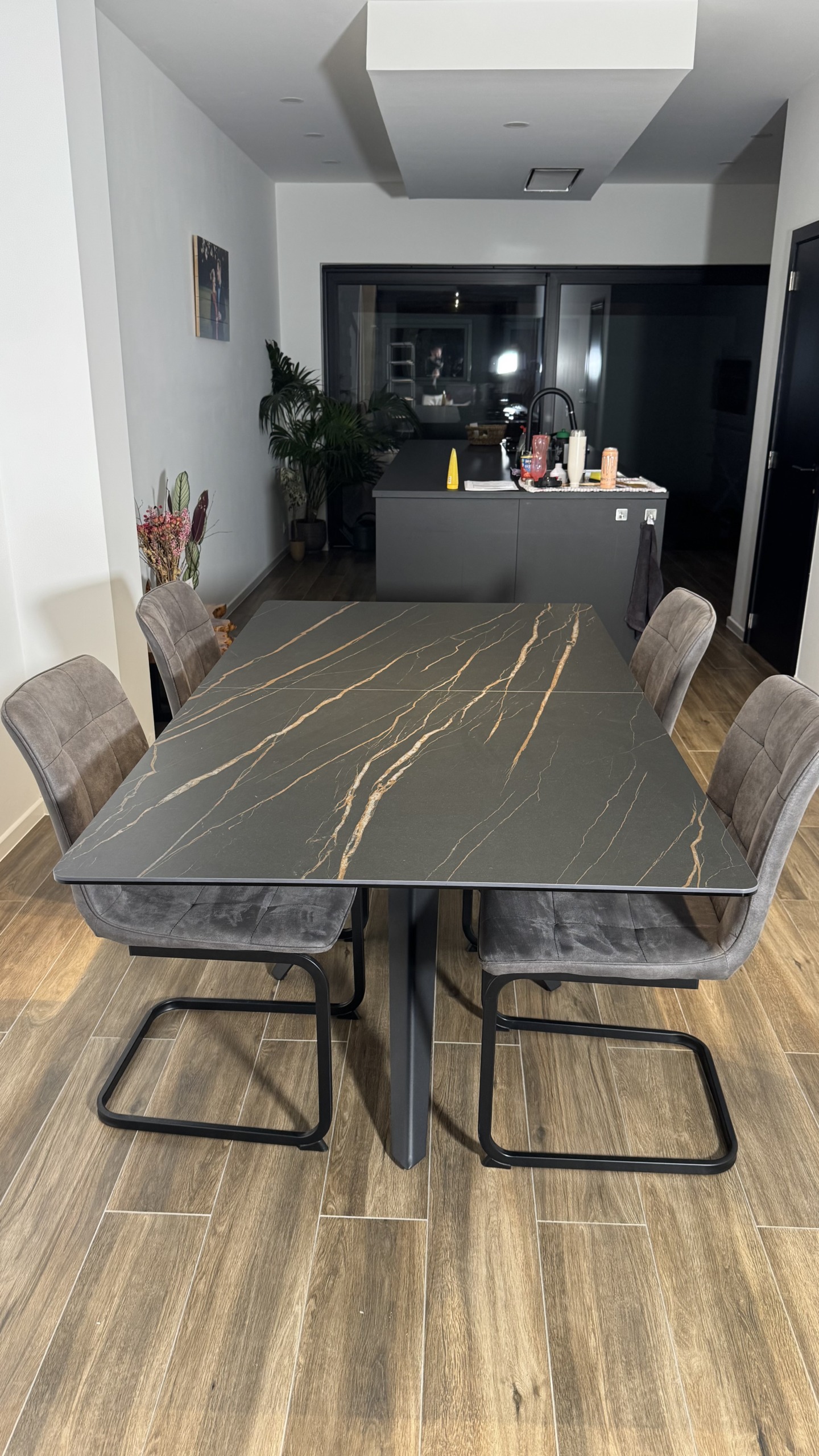 Eettafel met keramisch blad in donkere marmerlook en stoelen in grijze stof