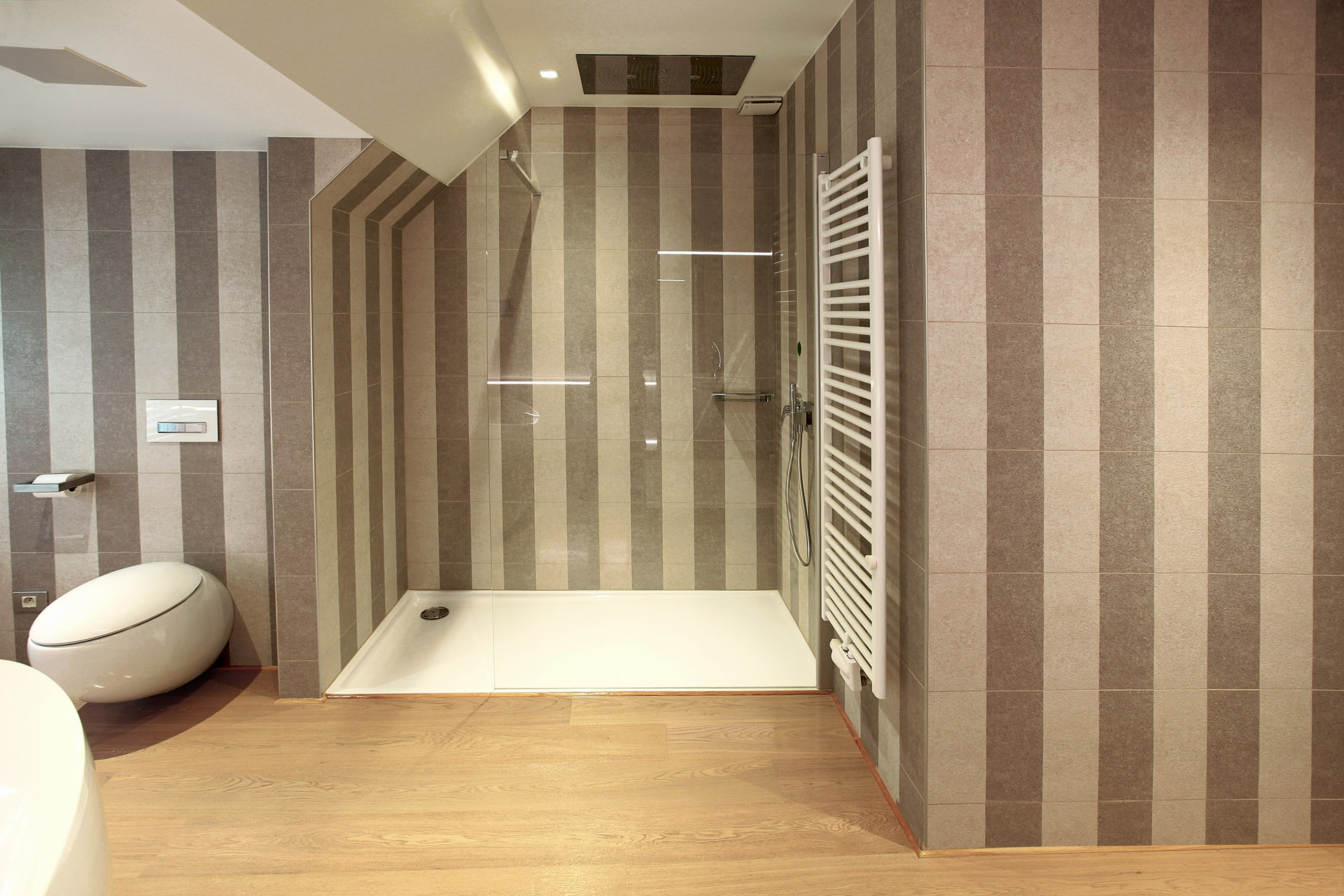 Inloopdouche achter glas met gestreepte natuursteentegels