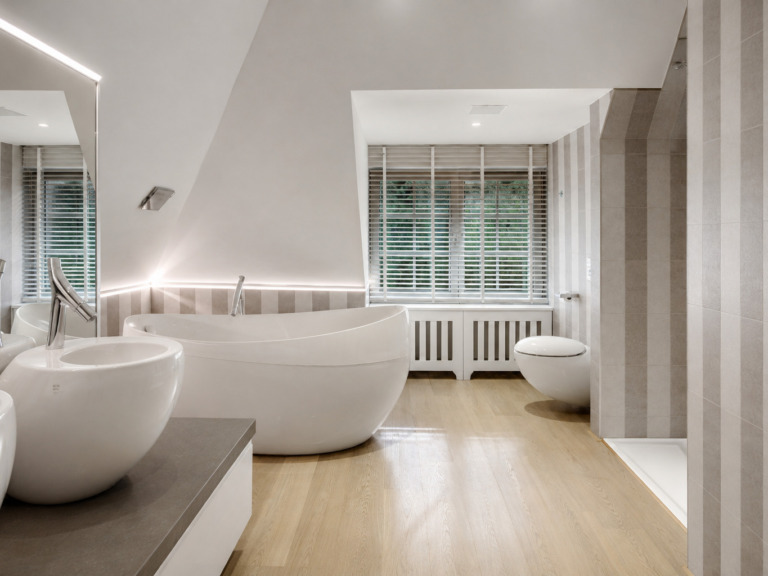 Badkamer in Antwerpen onder de dakschuinte, met vrijstaand bad en houten vloer