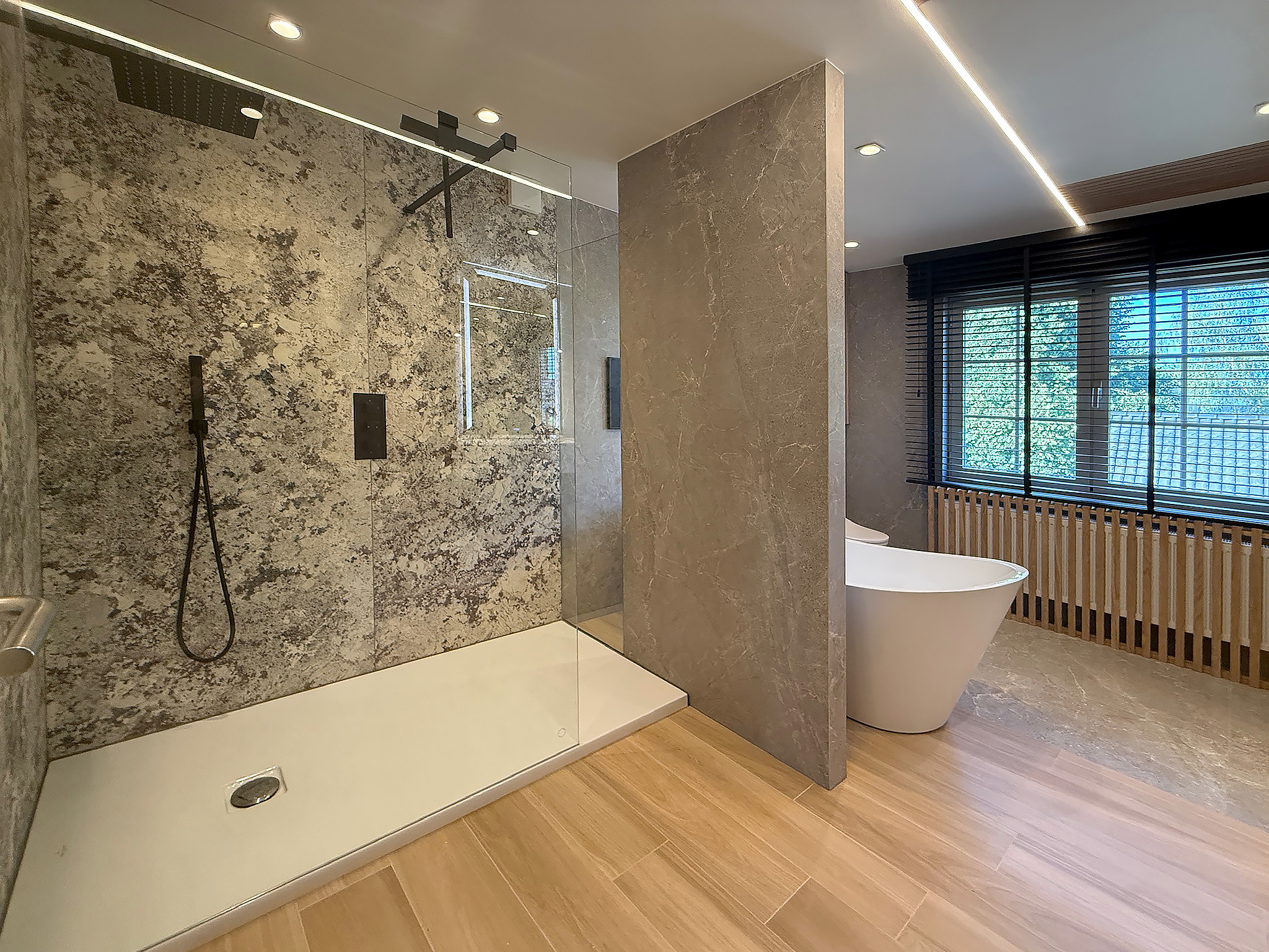 Zicht vanuit de douche op het vrijstaande bad voor het raam, badkamer in Westerlo