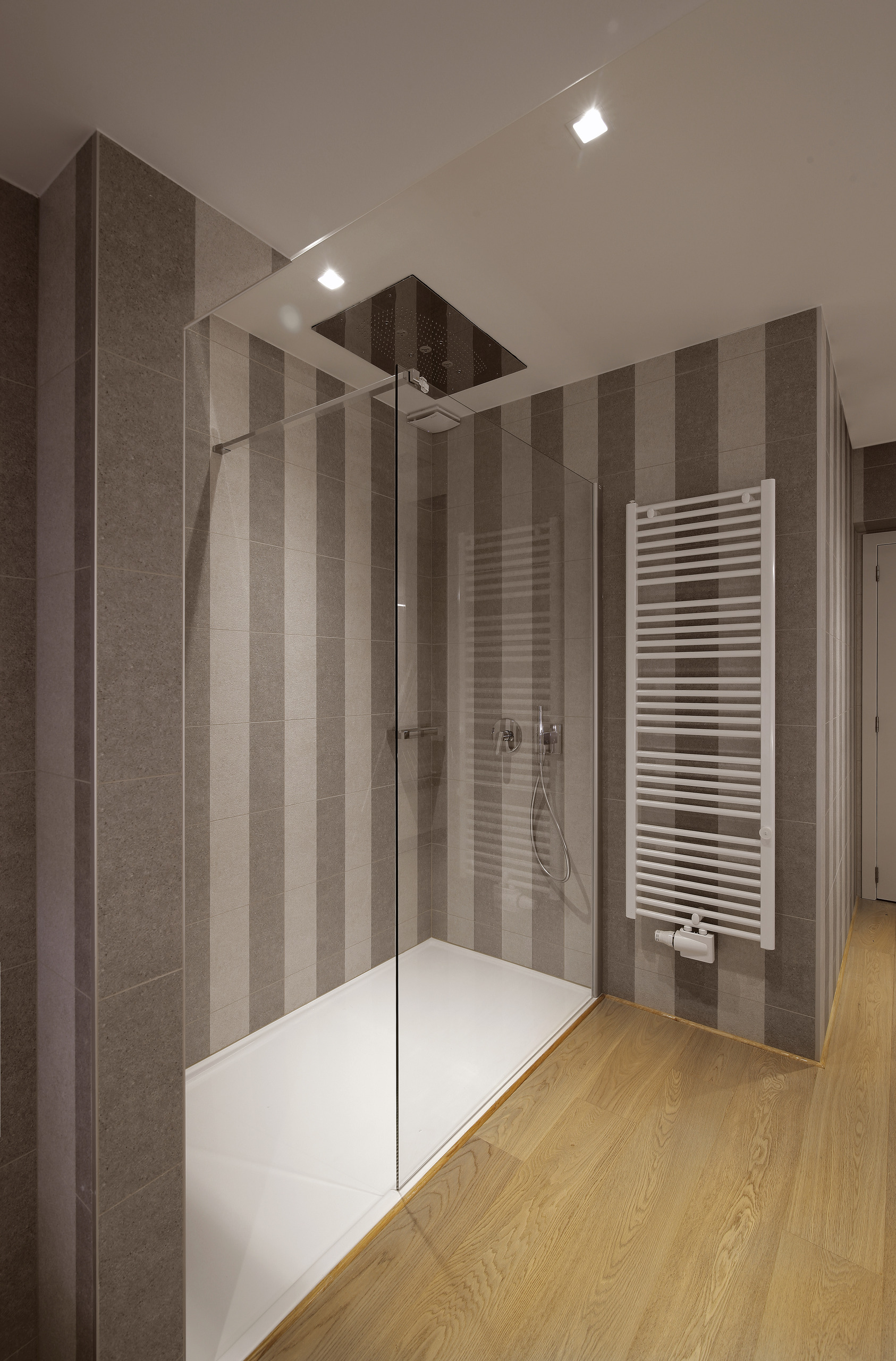 Inloopdouche met vast glas en een witte handdoekradiator, badkamer in Antwerpen