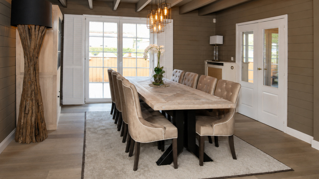 Landelijke eetkamer in Overijse met eiken tafel, velours stoelen en drijfhoutlamp