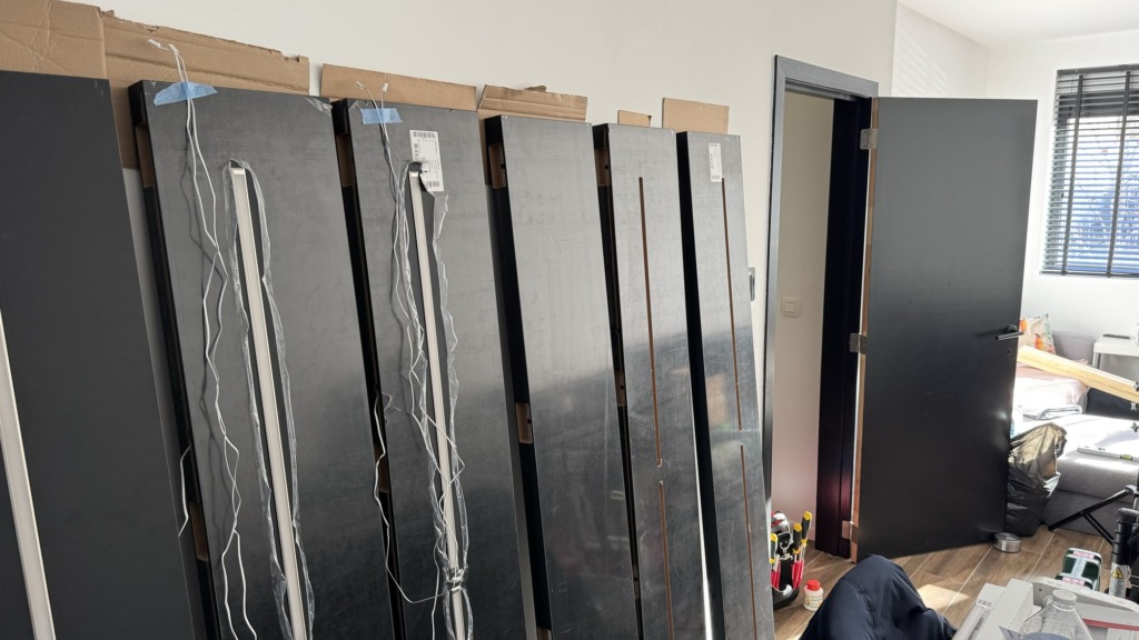 Mat zwarte panelen van de tv-kast, geleverd en klaargezet met de ledprofielen