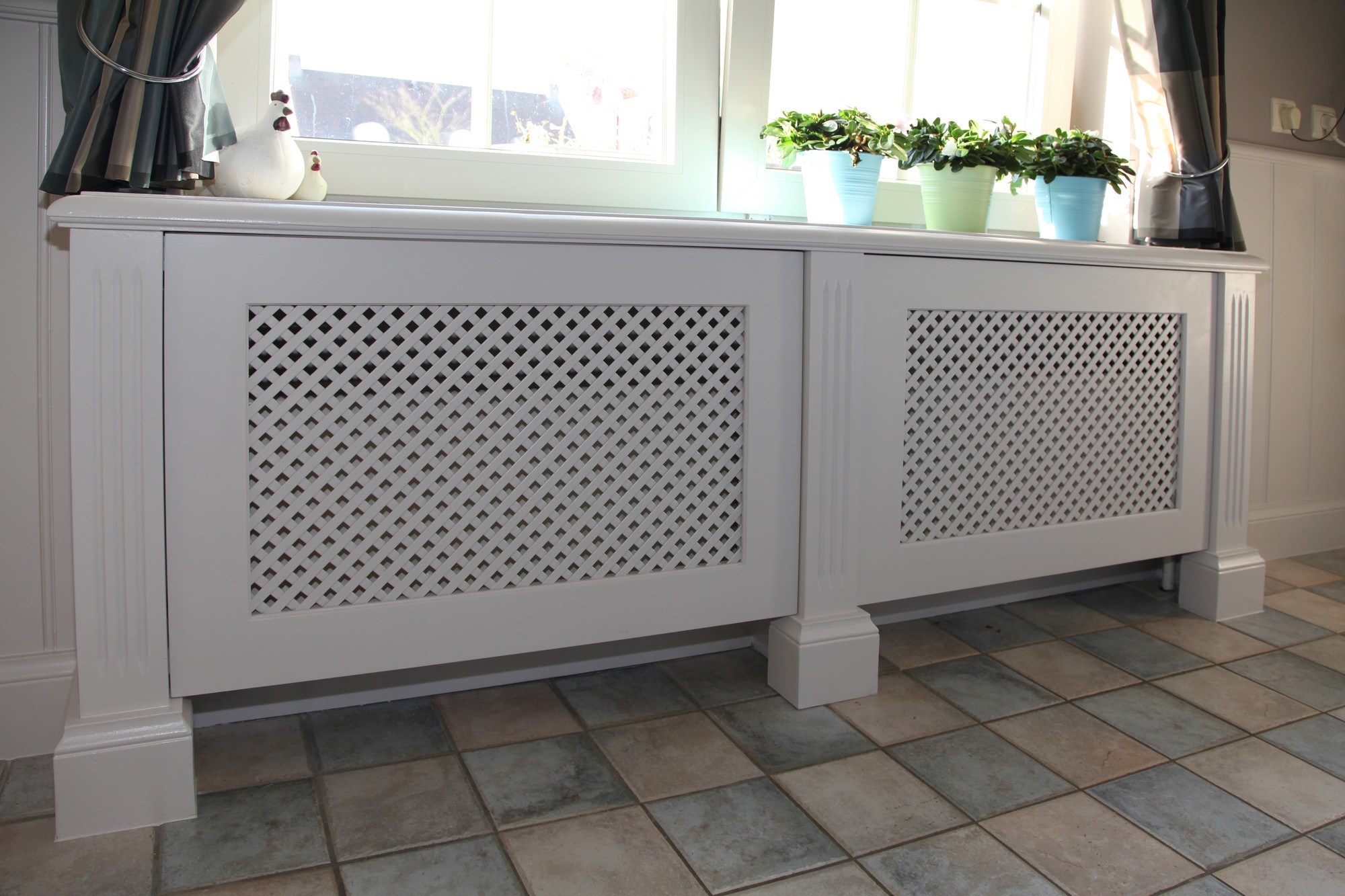 Radiatorombouw met traliewerk in ruitmotief naast de keuken
