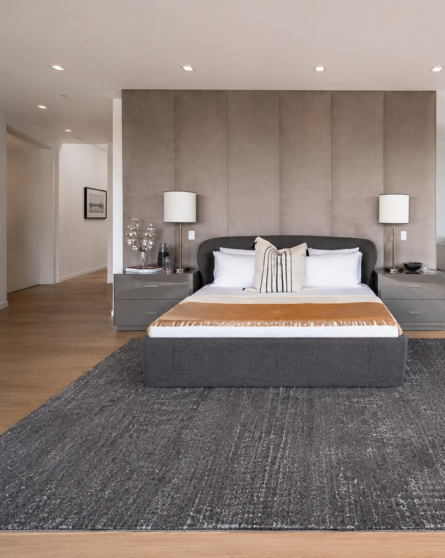 Slaapkamer in vooraanzicht met het bed tegen een gestoffeerde wand