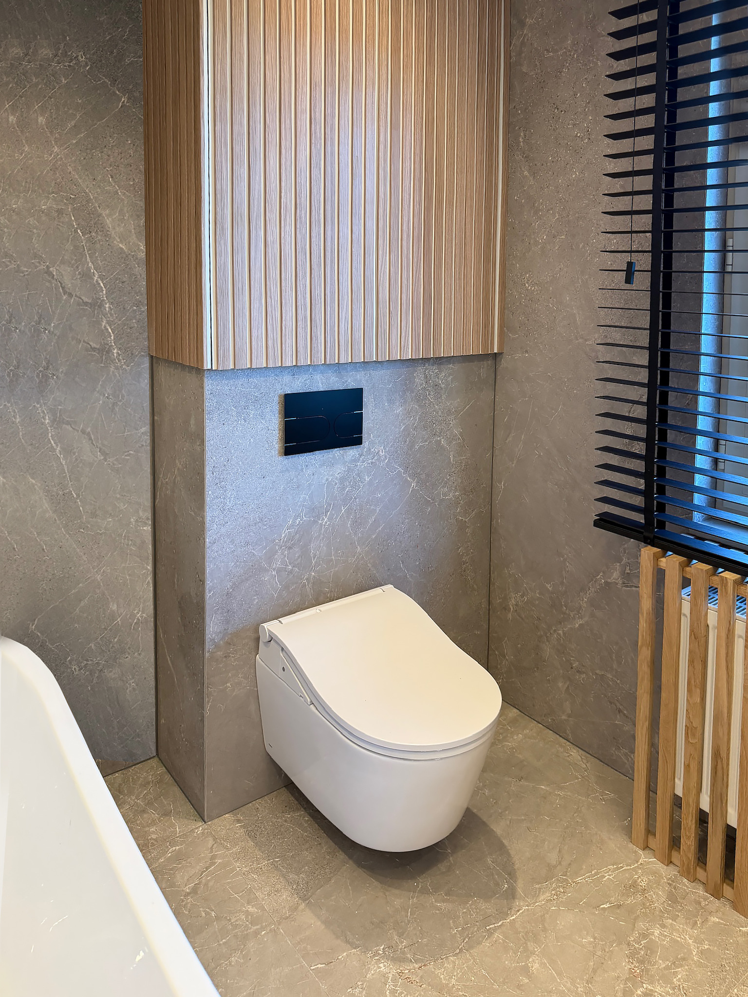 Zwevend toilet tussen de eiken lattenwand en de radiator, badkamer in Westerlo