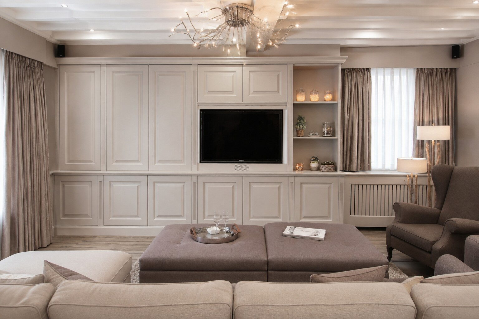 Gepaneelde wand met de televisie tussen twee nissen met verlichting