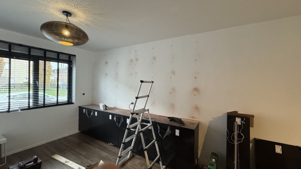 De kale wand in de leefruimte voor de plaatsing van de tv-kast op maat