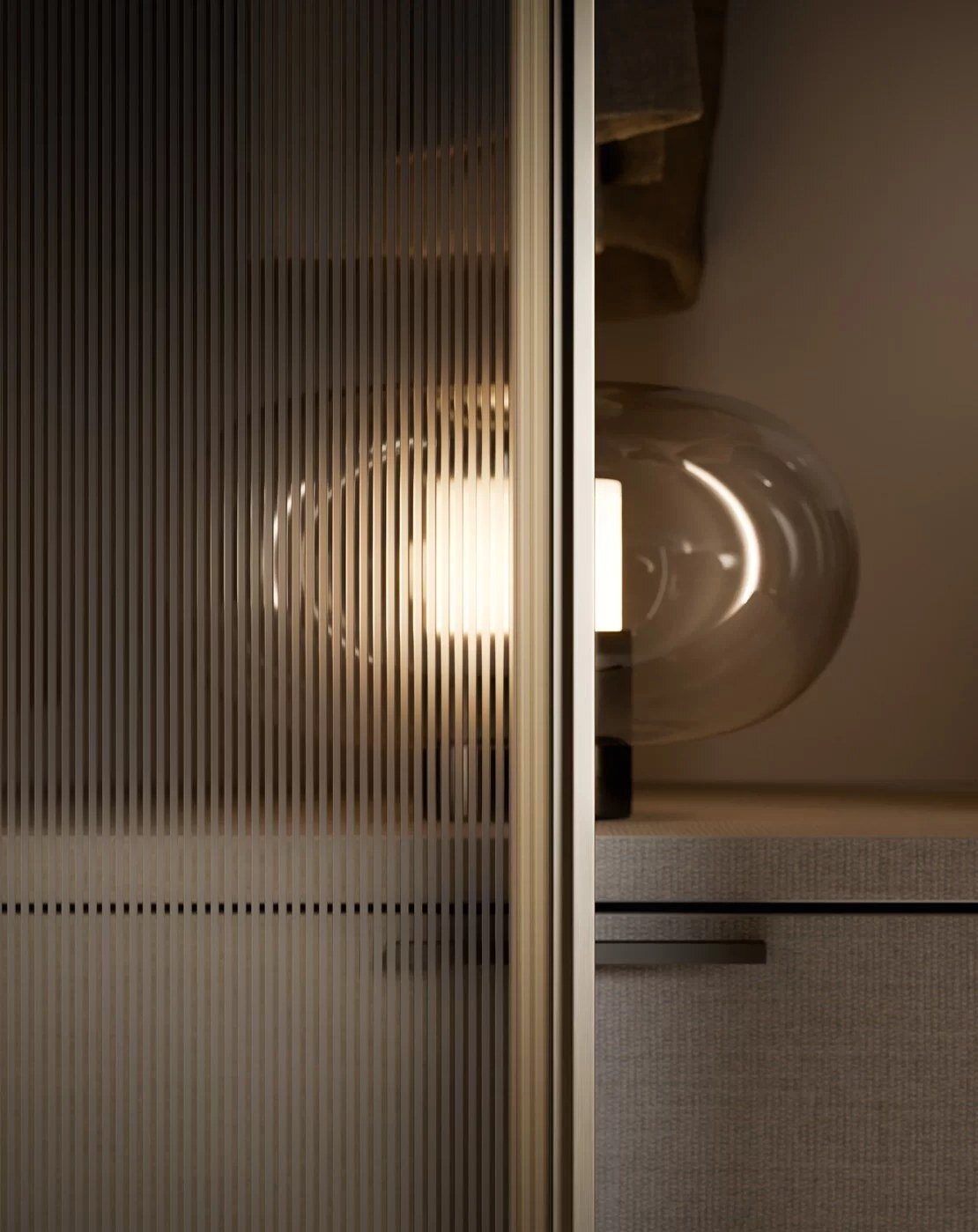 Geribd glas in een kastdeur, met daarachter een warme glazen hanglamp en een linnen ladefront