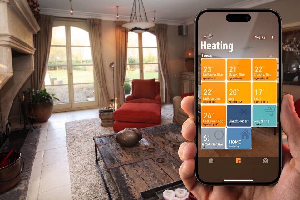 Een telefoon met de verwarming per ruimte op het scherm, voor een zithoek met open haard.