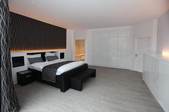 Kasten in witte lak zonder grepen, over de volle breedte van de wand.