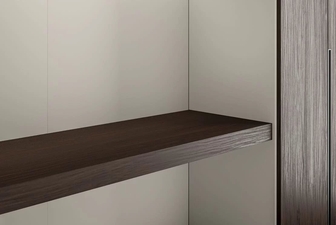 A wooden shelf inside a cabinet, against a pale back panel.