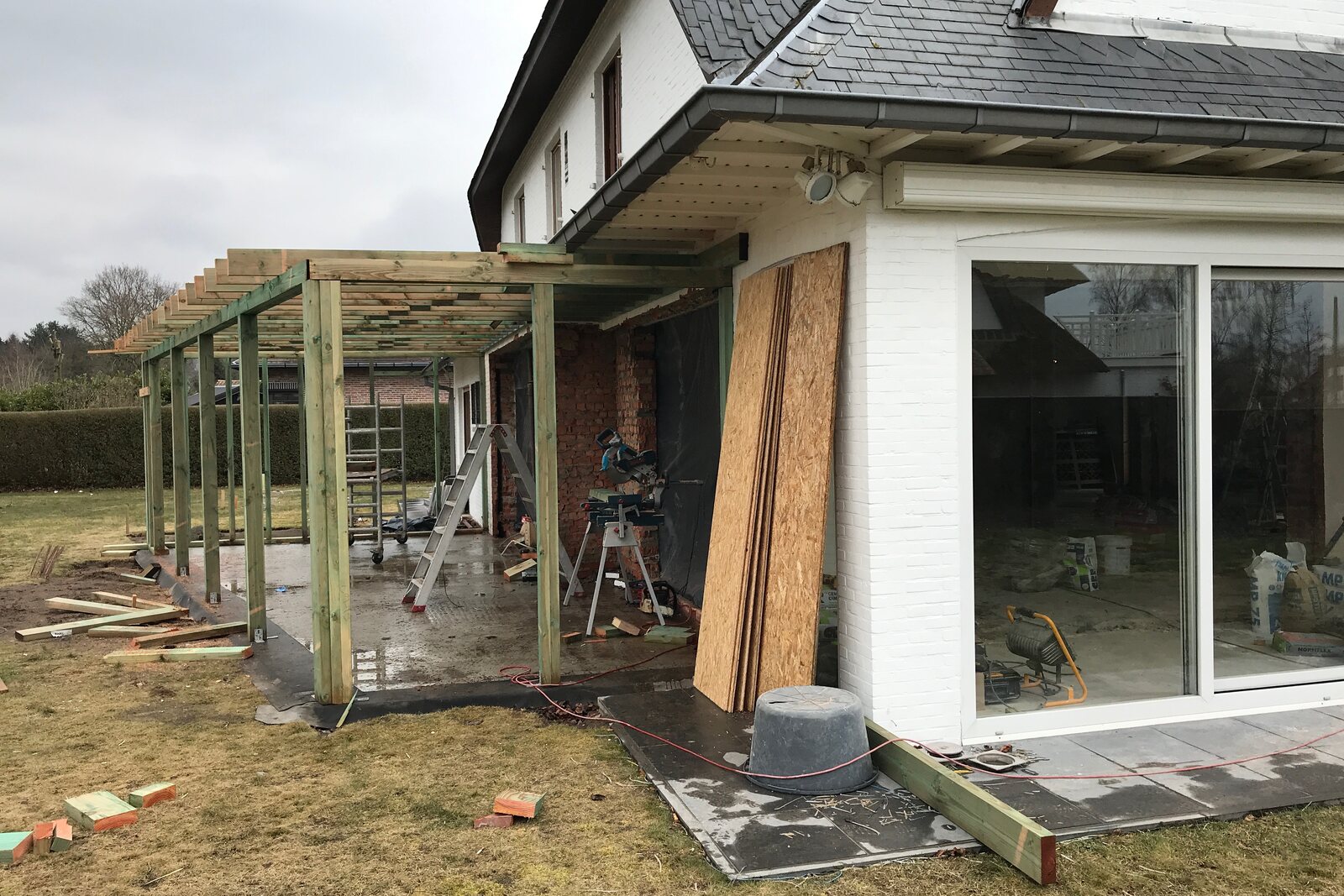 Die Stahlkonstruktion einer Orangerie im Bau, mit Stützen und Material auf der Baustelle.
